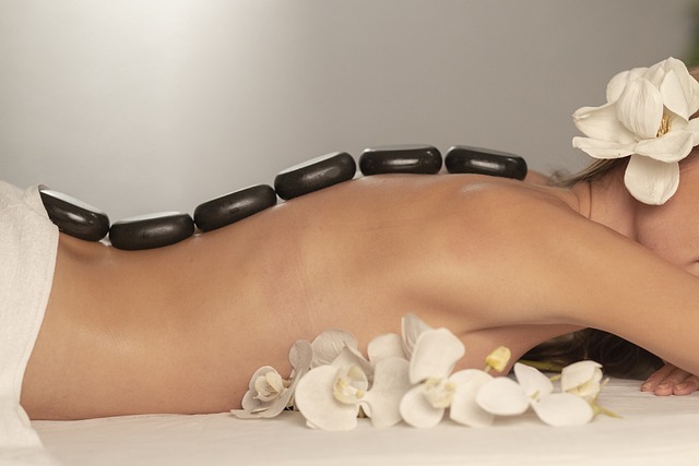Imagen de una mujer relajada con rocas calientes en la espalda en un spa, disfrutando de un tratamiento de bienestar y relajación.